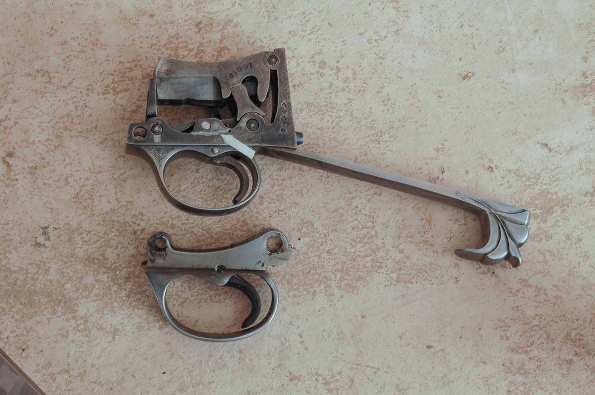 A Cadet trigger assembly (top) shows where metal must be welded (arrow) on to a G.P. trigger assembly (bottom) for trigger blocking safety.Looking down into the G.P. trigger guard, the arrow points to the top of the trigger. Anywhere below this surface could be fitted with a trigger blocking safety.